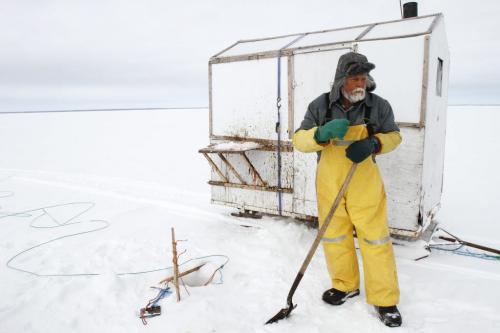 Once drilled, ice fisherman Frank Kenyon must remove excess ice and slush from the hole with a shovel before the gill net containing its catch can be retrieved from the water below. Tuesday, March 26, 2013. (REPORTER: BARTLEY KIVES) (JESSICA BURTNICK/WINNIPEG FREE PRESS)