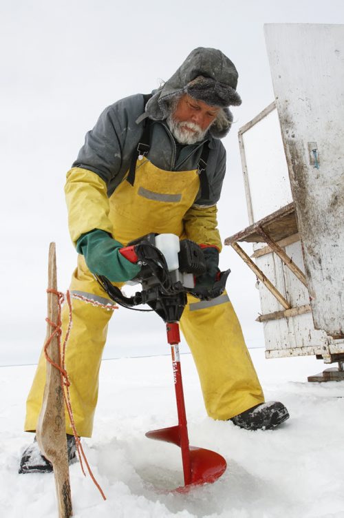 Fairford, Man. ice fisherman Frank Kenyon uses a gas powered auger to drill a hole into the ice where one of his 45 gill nets is set on Lake Manitoba. The site is marked with a stake. Tuesday, March 26, 2013. (REPORTER: BARTLEY KIVES) (JESSICA BURTNICK/WINNIPEG FREE PRESS)