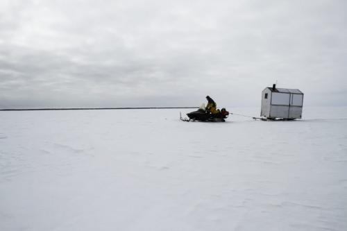 Fairford, Man. ice fisherman Frank Kenyon pulls a wooden shack on skis behind his snow machine onto Lake Manitoba. The shack contains a stove so the fishermen can warm up on cold days. Tuesday, March 26, 2013. (REPORTER: BARTLEY KIVES) (JESSICA BURTNICK/WINNIPEG FREE PRESS)