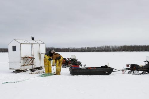 (Left to right) Fairford, Man. ice fishermen Frank Kenyon and Randy Strawa draw in one of about 45 gill nets they've set on Lake Manitoba to take in their catch. Tuesday, March 26, 2013. (REPORTER: BARTLEY KIVES) (JESSICA BURTNICK/WINNIPEG FREE PRESS)