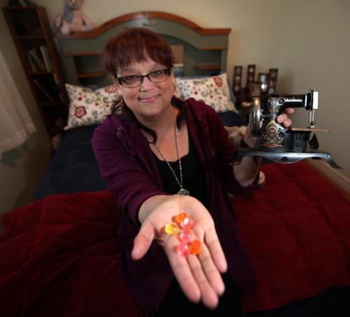 MY STUFF  Renee Morin, co-owner of The Little Dog House  Small Dog Center poses on her bed holding a toy sewing machine and her favorite citrus lozenge April 3, 2013 - (Phil Hossack / Winnipeg Free Press)