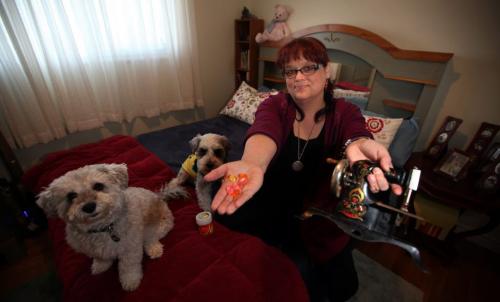 MY STUFF  Renee Morin, co-owner of The Little Dog House  Small Dog Center poses on her bed holding a toy sewing machine and her favorite citrus lozenge April 3, 2013 - (Phil Hossack / Winnipeg Free Press)