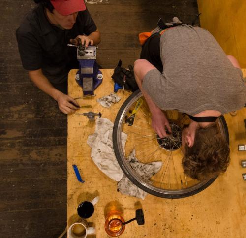 Co-op member Andrew Dalton (right) tightens wheel spokes with mechanic Graham Madden at Natural Cycle in the Exchange District - a co-op owned repair shop and store. 130403 - Wednesday, April 03, 2013 - (Melissa Tait / Winnipeg Free Press)
