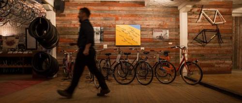Will Belford passes by a display of bikes for sale. Natural Cycle in the Exchange District is a co-op owned repair shop and store. Custom bicycle builds, using new and used parts, is common. 130403 - Wednesday, April 03, 2013 - (Melissa Tait / Winnipeg Free Press)
