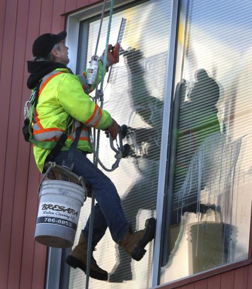 Reg Anderson cleans windows suspended off the federal gov't building at 365 Hargrave St. enjoying the mild sunny weather Thursday morning.  (WAYNE GLOWACKI/WINNIPEG FREE PRESS) Winnipeg Free Press April 4 2013