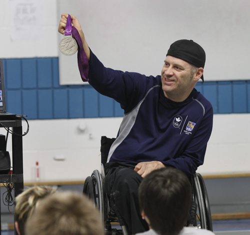 Multiple Paralympic medalist for wheelchair rugby, Jared Funk holds his silver medal from London 2012 and Curling Champion Jill Officer gave inspiring presentations to students at Starbuck School in Starbuck Manitoba Monday. The school got the honour to have the athletes attend because Larry McCrady of Morris won their guest appearance through a Pennies from Heaven draw and decided to have them attend a nearby elementary school his grandson attends so the kids in K to Gr. 8 could see them. They are part of the  RBC Olympians program who bring the Olympic messages of excellence and leadership to Canadian communities.(WAYNE GLOWACKI/WINNIPEG FREE PRESS) Winnipeg Free Press April 8 2013