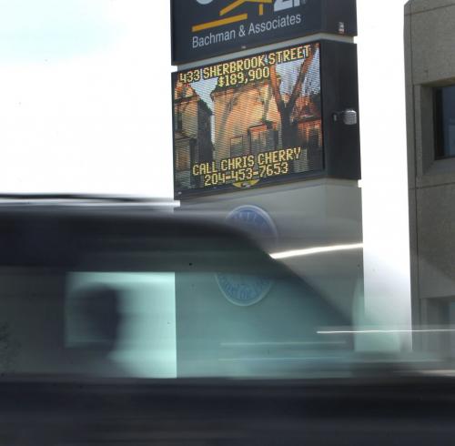 A motorist passes by an electronic sign on McMillan ave. towards confusion corner that at times scrolls with ads. (It is Century 21's sign) . Winnipeg is finally set to approve a host of new regulations around electronic signs which will ban scrolling text and animation. If approved by council, the new rules will take effect later this month. Jen Skerritt  Story  (WAYNE GLOWACKI/WINNIPEG FREE PRESS) Winnipeg Free Press April 9 2013