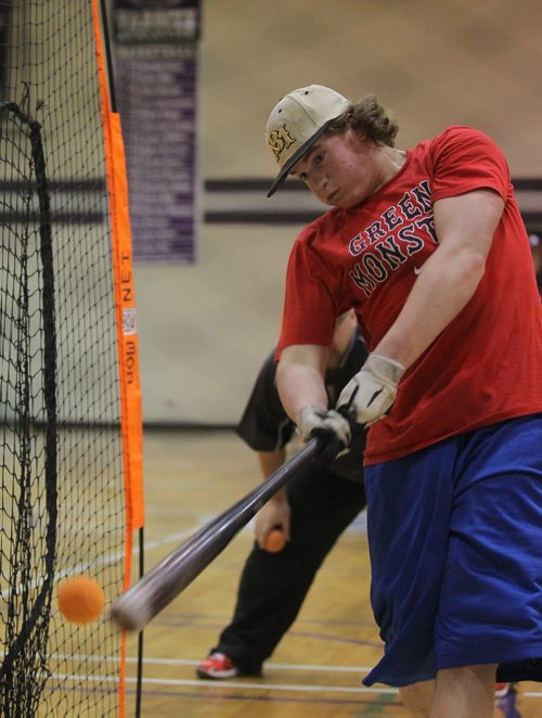 Brandon Sun Under the ye of head coach Farron Asham, Vikings Clark Whelpton connects with a ball during batting practice in the Massey Gym on Tuesday. (Bruce Bumstead/Brandon Sun)