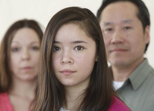 In centre,  Sage Hryciw-Pang with her parents Pam and Lionel.  The family is saying Sage has been bullied out of soccer by coaches and officials. They have asked for a transfer from North West area and have been denied and not given a reason. Ashley Prest   story.  (WAYNE GLOWACKI/WINNIPEG FREE PRESS) Winnipeg Free Press April 10 2013