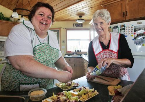 Betty Reimer (right) and Charlotte Penner (left) prepare a goat cheese pear salad with maple balsamic. The duo created the popular cookbook, Mennonite Girls Can Cook and have just finished a new cookbook, Mennonite Girls Can Cook Celebrations. 130411 April 11, 2013 Mike Deal / Winnipeg Free Press