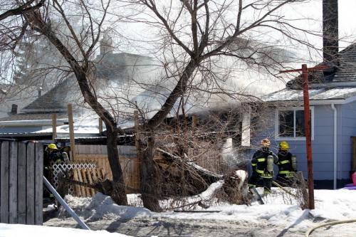 Fire Fighters work in a crammed space to put out a small home on Union Ave. Saturday afternoon.  All her family members got safely out of the home but her family dog may have died in the blaze. See Geoff Kirbyson's story. Photography Ruth Bonneville Ruth Bonneville /  Winnipeg Free Press)