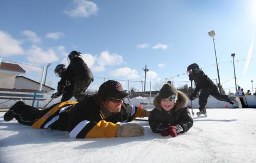 Roblin Park Community Club ice maker Marcy Beaucage, broke the record for the latest ever outdoor hockey rink in his lifetime of ice making Saturday when he iced the rink the night before and told members to come out for a game of "Shinny" Saturday.  Lee Beaucage  plays a little hockey with his nephew Kiedis Chudyk Saturday morning. Photography Ruth Bonneville Ruth Bonneville /  Winnipeg Free Press)