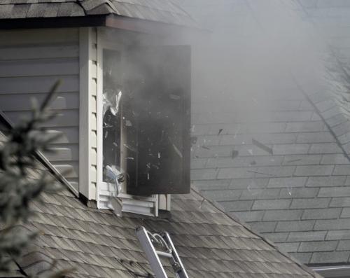 Firefighters break glass as smoke pours out of a second floor window at a house fire on Union Street, Saturday, April 13, 2013. (TREVOR HAGAN/WINNIPEG FREE PRESS)