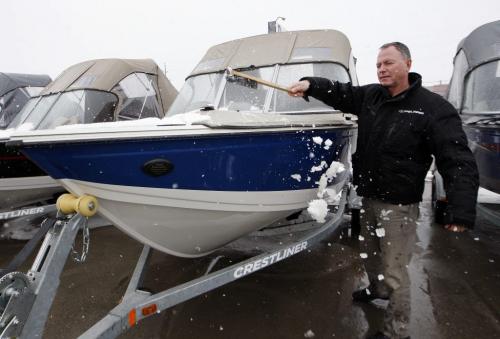 Season Product sales effected by the lingering  winter Äì Jeff Snowdon of Rond's Marine  pushes  snow of  power boat . Biz story by Murray McNeill,-  Regent Ave Canadian Tire general Mgr.  Rob Petkau  with season merchandise  ready to move when the weather warms up . KEN GIGLIOTTI / April . 15 2013 / WINNIPEG FREE PRESS