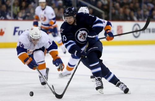 Winnipeg Jets' Kyle Wellwood (13) skates around New York Islanders' Thomas Hickey (14) before scoring his second goal of the second period during NHL action at MTS Centre in Winnipeg, Saturday, April 20, 2013. (TREVOR HAGAN/WINNIPEG FREE PRESS)