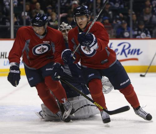 Winnipeg Jets' Antti Miettinen (20) and Arturs Kulda (23) race to the puck in front of goaltender Ondrej Pavelec (31) during practice at MTS Centre in front of about 3000 fans from the ticket waiting list who were invited to the special event, Sunday, April 14, 2013. (TREVOR HAGAN/WINNIPEG FREE PRESS)