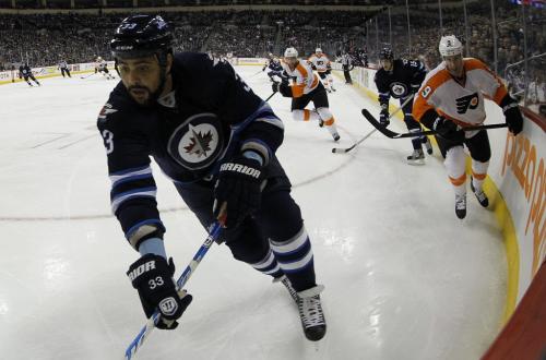 Winnipeg Jets' Dustin Byfuglien (33) reaches for the puck as he is pursued by Philadelphia Flyers Mike Knuble (9) at MTS Centre in Winnipeg, Saturday, April 6, 2013. (TREVOR HAGAN/WINNIPEG FREE PRESS)
