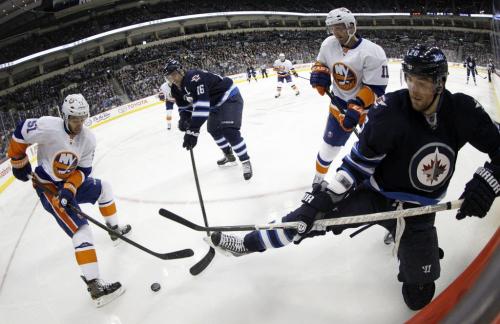 New York Islanders' Frans Nielsen (51) and Lubomir Visnovsky (11) battle for the puck with Winnipeg Jets' Andrew Ladd (16) and Blake Wheeler (26) during second period NHL action at MTS Centre in Winnipeg, Saturday, April 20, 2013. (TREVOR HAGAN/WINNIPEG FREE PRESS)