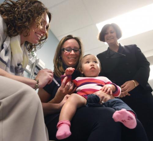 One year old Gabrielle on her mother Amanda Smeets lap finds out that taking part in a mock inoculation Tuesday with Annabelle Reimer, Nurse Practitioner at the St. Boniface QuickCare Clinic really doesn't hurt at all. This demonstration followed an announcement to media by Theresa Oswald, Health Minister at right, that this is Immunization Awareness Week and it is time for Manitobans to review their family's immunization status. Manitobans can now access immunizations at QuickCare clinics in Winnipeg, Steinbach and Selkirk.  see release.(WAYNE GLOWACKI/WINNIPEG FREE PRESS) Winnipeg Free Press April 23 2013