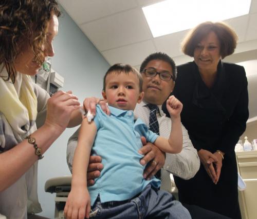 Three year old Dion sitting on his father Joey Smeets knee finds out that taking part in a mock inoculation Tuesday with Annabelle Reimer, Nurse Practitioner at the St. Boniface QuickCare Clinic really doesn't hurt at all. This demonstration followed an announcement to media by Theresa Oswald, Health Minister at right, that this is Immunization Awareness Week and it is time for Manitobans to review their family's immunization status. Manitobans can now access immunizations at QuickCare clinics in Winnipeg, Steinbach and Selkirk.  see release.(WAYNE GLOWACKI/WINNIPEG FREE PRESS) Winnipeg Free Press April 23 2013