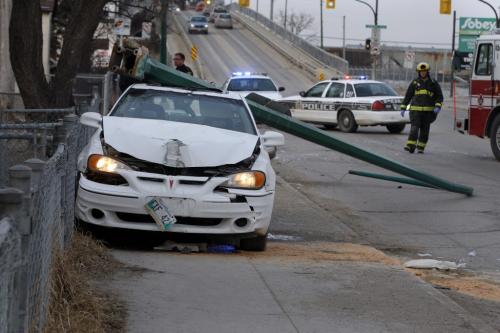 Wpg police investigate a single vehicle MVC with a light standard on Arlington St at Dufferin Ave. just after 7am , at least one person was taken to hospital , the car was  on the sidewalk with the light standard  on top of it . KEN GIGLIOTTI / April . 24 2013 / WINNIPEG FREE PRESS