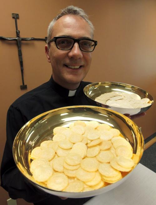 Roman Catholics adopt low-gluten communion hosts to accommodate allergies. Father Darrin Gurr. Dir of liturgy archdiocese of Winnipeg poses with some of the new(foreground) and old (back) in the office of St. Gianna Beretta Roman Catholic Church, 1355 Kenaston Ave (in a strip mall). April 26, 2013  BORIS MINKEVICH / WINNIPEG FREE PRESS