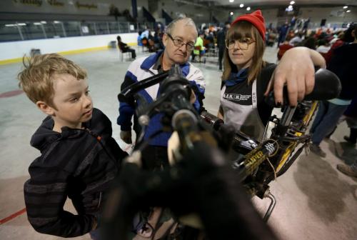 Ben Peters, 10, his dad, Dan, and Robin Ellis, a mechanic from The Wrench, working on Bens new bike at the bike auction at Varsity View Community Centre, Saturday, April 27, 2013. (TREVOR HAGAN/WINNIPEG FREE PRESS)