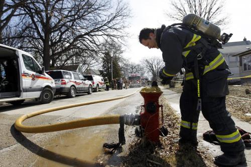 A firefighter turns off the hydrant at a fire on the 200 block of Trent Avenue, Sunday, April 28, 2013. (TREVOR HAGAN/WINNIPEG FREE PRESS)