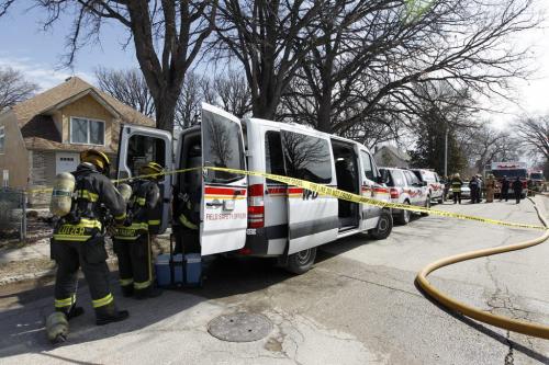 Firefighters make adjustments to their air tanks at a fire on the 200 block of Trent Avenue, Sunday, April 28, 2013. (TREVOR HAGAN/WINNIPEG FREE PRESS)