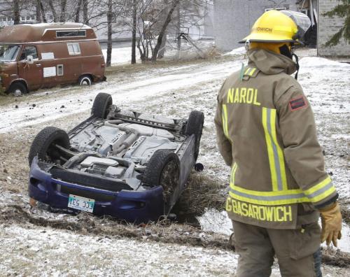 Members of the Narol Fire Dept. stand by a vehicle that rolled into a ditch along Henderson Hwy. south of Lockport Wednesday morning that sent to people to the hospital to be checked out. Wayne Glowacki/ Winnipeg Free Press May 1 2013