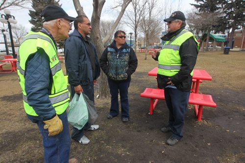 Brandon Sun Paul Criddle, left, and Ralph Warman of the Citizens on Patrol Program (COPPS), stop to introduce themselves to a couple passing through Princess Park on Wednesday afternoon. (Bruce Bumstead/Brandon Sun)