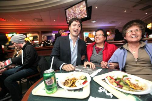 Liberal leader Justin Trudeau talks with the media and greets people in the food court at TD Centre in Winnipeg  over the lunch hour Thursday with MP Kevin Lamoureux.  Names - Florita Pacle in red and Lorie Turtal enjoy meeting Trudeau during their lunch hour.  Photography Ruth Bonneville Ruth Bonneville /  Winnipeg Free Press)