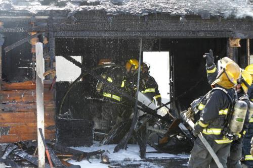 Winnipeg Fire Fighters extinguish a garage behind a house in the 1000 block of Magnus Ave. and a garage that was also burning across the back lane  on Burrows Ave. near McPhillips St. Monday morning. (WAYNE GLOWACKI/WINNIPEG FREE PRESS) Winnipeg Free Press May 6 2013
