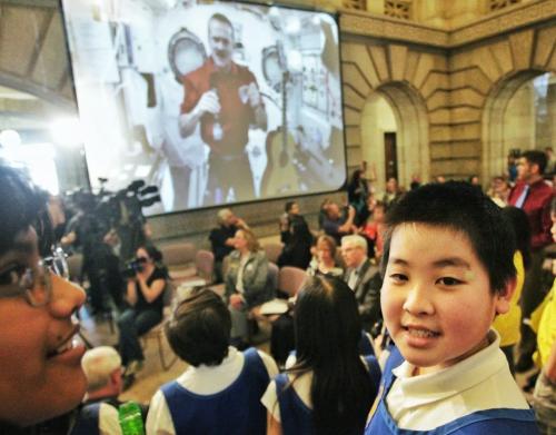 Kevin Li, 10, a student from Dalhousie School reacts with a smile when a live video feed of Commander Chris Hatfield who is on the International Space Station appeared on the screens set up in the foyer of the Manitoba Legislative Building. Thousands of students from across the country are celebrating Music Month today by singing together via a live feed with Commander Hatfield.  130506 May 06, 2013 Mike Deal / Winnipeg Free Press