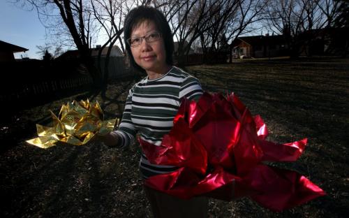 Maria Cheung shows off a pair of symbolic "Lotus Flowers" Monday evening. See Brenda Suderman's story re: Falun Gong celebrate 21st anniversary May 6, 2013 - (Phil Hossack / Winnipeg Free Press)