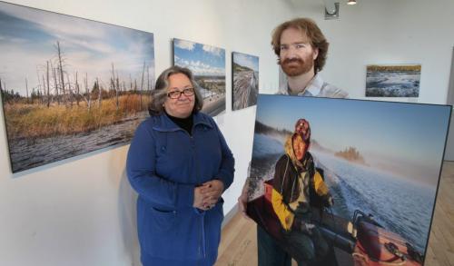 Ellen Cook, aboriginal elder and Blair Barkley, curator of the show of  photographs by Matt Sawatzky in an exhibit called Sad Sort of Clean, Hydropower In Northern Manitoba. At left is a photograph titled CEDAR LAKE and Blair holds a portrait of Robert  Spence titled APPETITE. The exhibit is in the Flatlanders Studio in the Winnipeg Centre Vineyard.  (WAYNE GLOWACKI/WINNIPEG FREE PRESS) Winnipeg Free Press May 8 2013