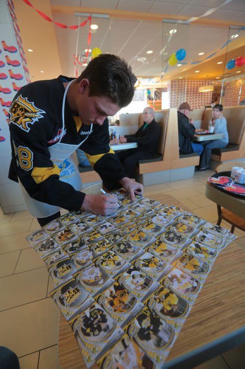 Brandon Sun Brandon Wheat Kings' Quintin Lisoway autographs a series of player cards at the RIchmond Avenue McDonald's during McHappy Day on Wednesday. (Bruce Bumstead/Brandon Sun)