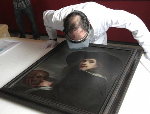 Radovan Radulovic, Head Conservator at the WAG inspects the work of art  titled SELF-PoRTRAIT WITH SKULL by Flemish painter Michiel Sweerts before it is hung at the at media event Thursday for the WAG 100 Masters exhibit in the Winnipeg Art Gallery.  Carolin Vesely story  (WAYNE GLOWACKI/WINNIPEG FREE PRESS) Winnipeg Free Press May 9 2013