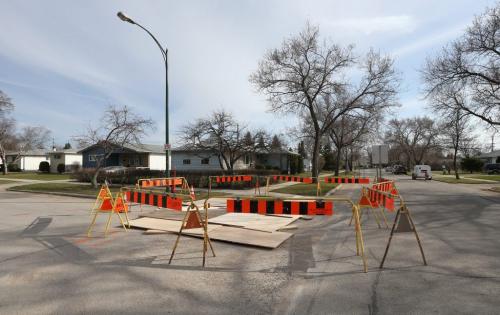 Boards cover a sinkhole that opened up in the road at the corner of Airlies Street and Ashbury Bay in Garden City in Winnipeg, Man., on Sun., May 12, 2013. Photo by Jason Halstead/Winnipeg Free Press