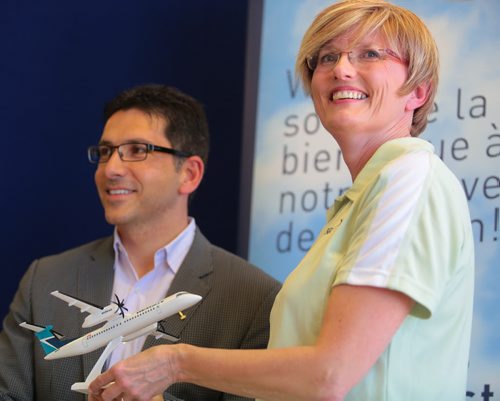 Brandon Sun Mayor Shari Decter Hirst grins ear-to-ear during a photo-op with WestJet Encore president Ferio Pugliese, left, following Monday's air service announcement at the Brandon Municipal Airport. The mayor was presented with a desktop model of the Bombardier Q400 turboprop plane which will fly daily from Brandon to Calgary starting in September. (Bruce Bumstead/Brandon Sun)