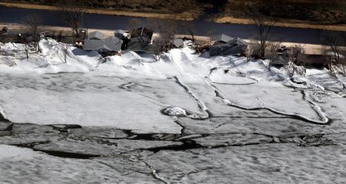 Ice pushes up against and pile up alongside homes in the community of Ochre Beach SouthEast of Dauphin Mb. Ice on Lake Dauphin (bottom) threatens to blow back onshore and do further damage Monday. See story. May 13, 2013 - (Phil Hossack / Winnipeg Free Press)