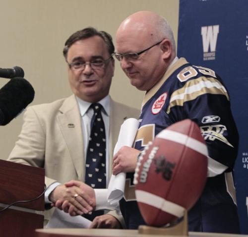 At left, Jerry Maslowsky with the Winnipeg Blue Bombers and David Hodge, Senior vice-president, Chief Information Officer at the Great-West Life Assurance Company at the announcement for the Kickoff Run relay June 22-June 27  that was  announced Tuesday at Great West Life Conference Centre. The relay will consist of 400 runners from across the province will be chosen or has won the chance to take part passing a CFL football in relay fashion on a route through several locations including, Winkler, Selkirk, Brandon and Gimli. The relay will also pass by former historical locations like the Osborne Stadium, Canad Inns Stadium then arriving at the Investors Group Field on June 27th Opening Ceremonies. see release.     (WAYNE GLOWACKI/WINNIPEG FREE PRESS) Winnipeg Free Press May 14 2013