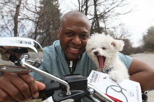 Donovan Gray MD sits on his new motorcycle with his dog "Steth" and his book "Dude where's my stethoscope and other stories from ER" - See Carolin Vesely's story.  Photography by Ruth Bonneville Winnipeg Free Press