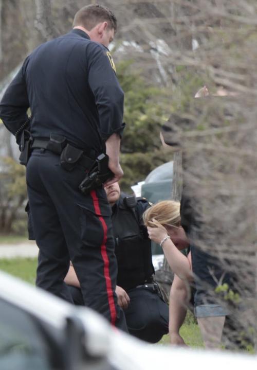 Distraught woman near home in the 4300 block on Roblin Blvd. Friday morning that is police taped off.(WAYNE GLOWACKI/WINNIPEG FREE PRESS) Winnipeg Free Press May 17 2013
