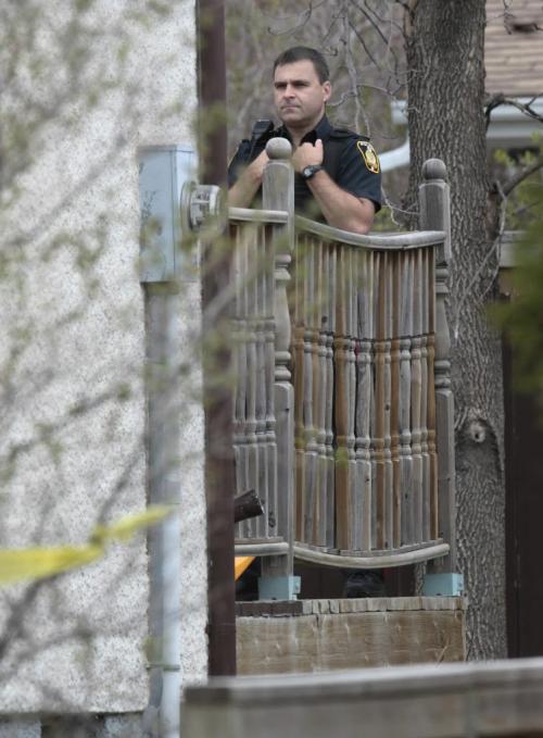 Winnipeg Police on the back yard deck of a home in the 4300 block of Roblin Blvd Friday morning that is tapped off.Alex Paul story. (WAYNE GLOWACKI/WINNIPEG FREE PRESS) Winnipeg Free Press May 17 2013
