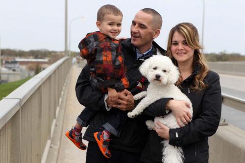Kevin Chief and his family - wife Melanie, son Hayden (2) and dog Buddy have their portrait taken on the Salter Street bridge looking north into Winnipeg's north end for story on his favourite place in the city.  May 18, 2013 Ruth Bonneville Winnipeg Free Press