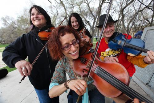 Local fiddlers have some fun fiddling under  the canopy at Coronation Park Saturday afternoon for the 1st annual World Fiddle Day.  Names from left Patti Lamoureux, Emilie Chartier,, Larry Martineau and Miriam Neuman (front)  Standup photo  May 18, 2013 Ruth Bonneville Winnipeg Free Press