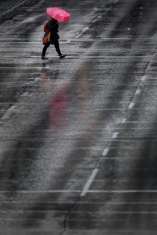 May 19, 2013 - 130519  -  A pedestrian crosses Portage Avenue during a day of rainfall Sunday, May 19, 2013. John Woods / Winnipeg Free Press