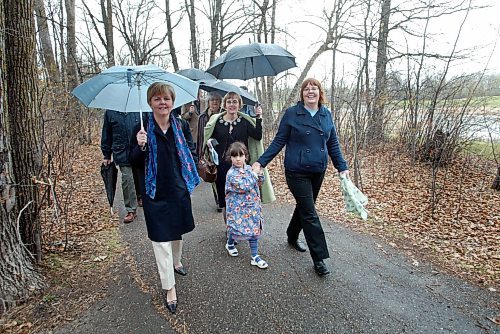 KEN GIGLIOTTI / WINNIPEG FREE PRESS / April 30 2007  - 070430 - Jen Skerritt  story - Family Affair -  Carol Shields  family  attended rain soaked   Carol Shields  Memorial Labyrinth sod turning ceremony  at King’s Park . In pic Shields daughters LtoR  Catherine Shields , Anne Giardini  , and Meg Shields with her daughter Emma age 4  (grand daughter to Carol Shields ) as they walk down  the picturesque path to the Labyrinth site