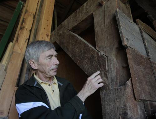 Ray Hamm by oak beams in the barn portion of his housebarn in Neubergthal, Mb. that have been notched and carved and held together with wooden pegs. The house is on the tour. Bill Redekop story     (WAYNE GLOWACKI/WINNIPEG FREE PRESS) Winnipeg Free Press May 22 2013